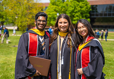 ea-honor-society Three graduates sporting regalia.