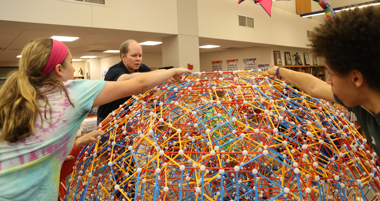 Taylor, Dr. Hill, and Brandon work together to complete the top.
