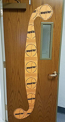 Integral Day posters form a large integral symbol on a door to the Math Suite.